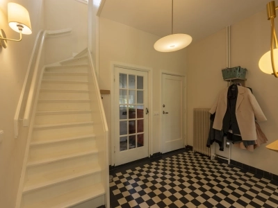 Hal met trap en zwart-wit tegelvloer – Hilversum